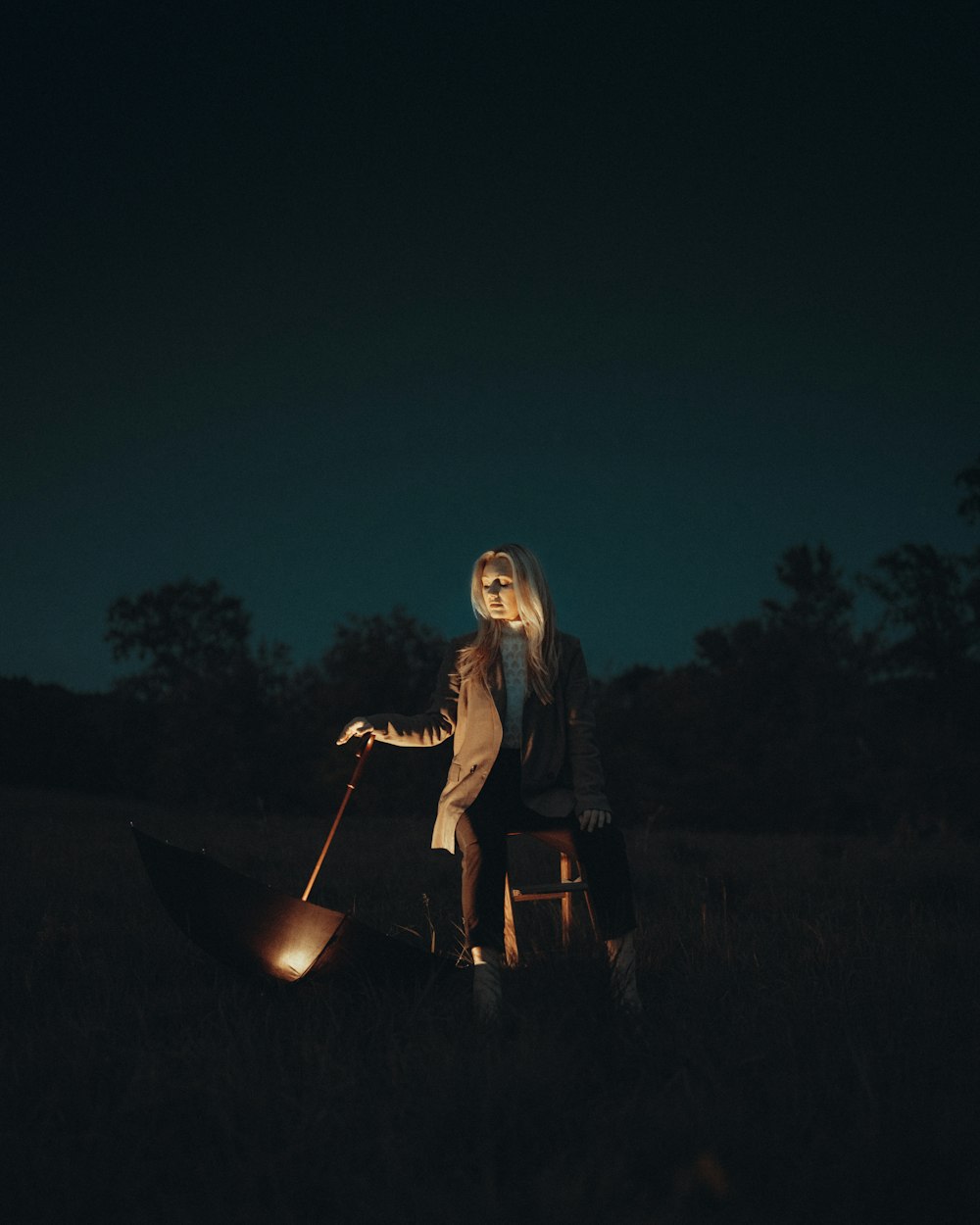 a woman standing in a field next to a fire