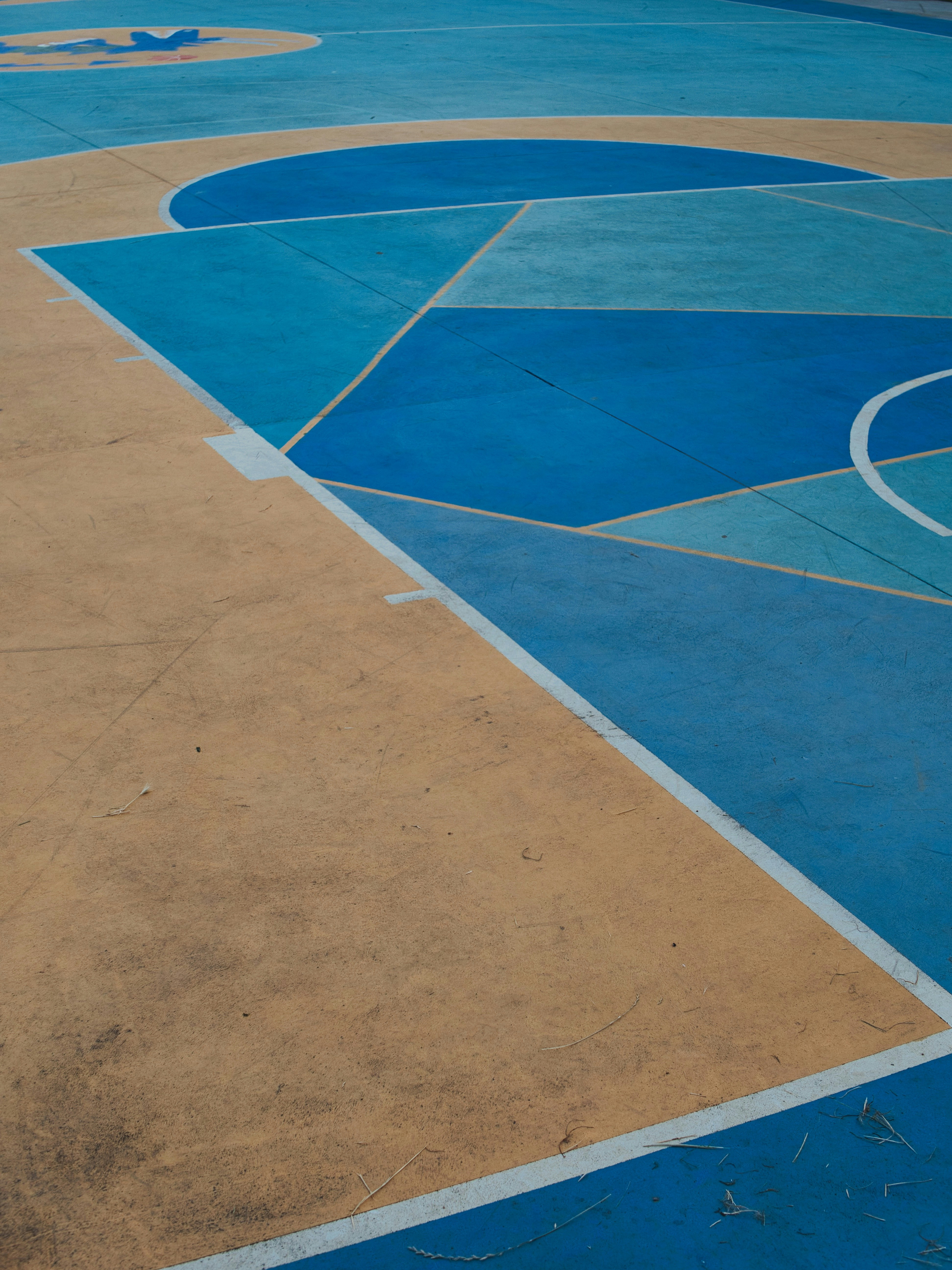 A basketball court with blue and yellow painted on it photo Free