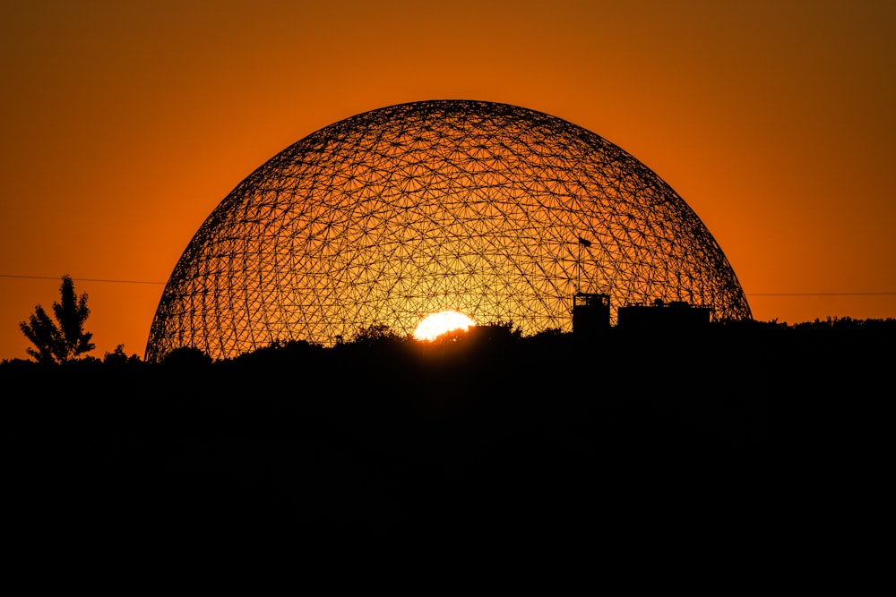 the sun is setting behind a dome structure