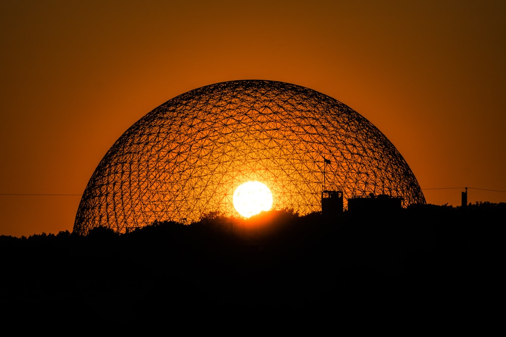 the sun is setting behind a dome structure