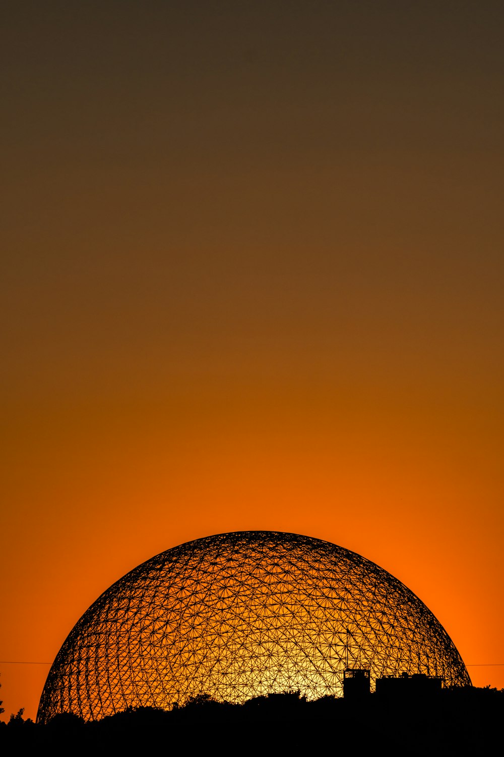 the sun is setting behind a dome structure