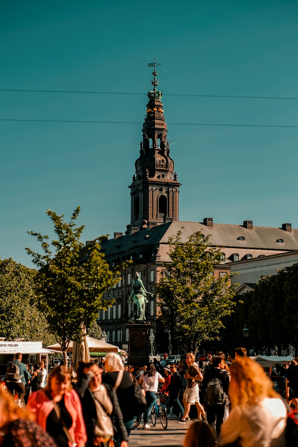 a crowd of people walking down a street next to a tall building