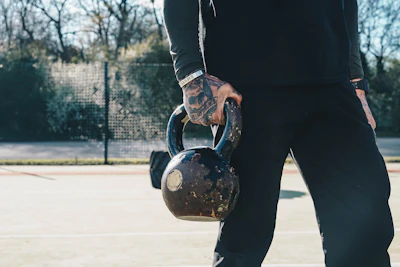 a man holding a kettle on a tennis court