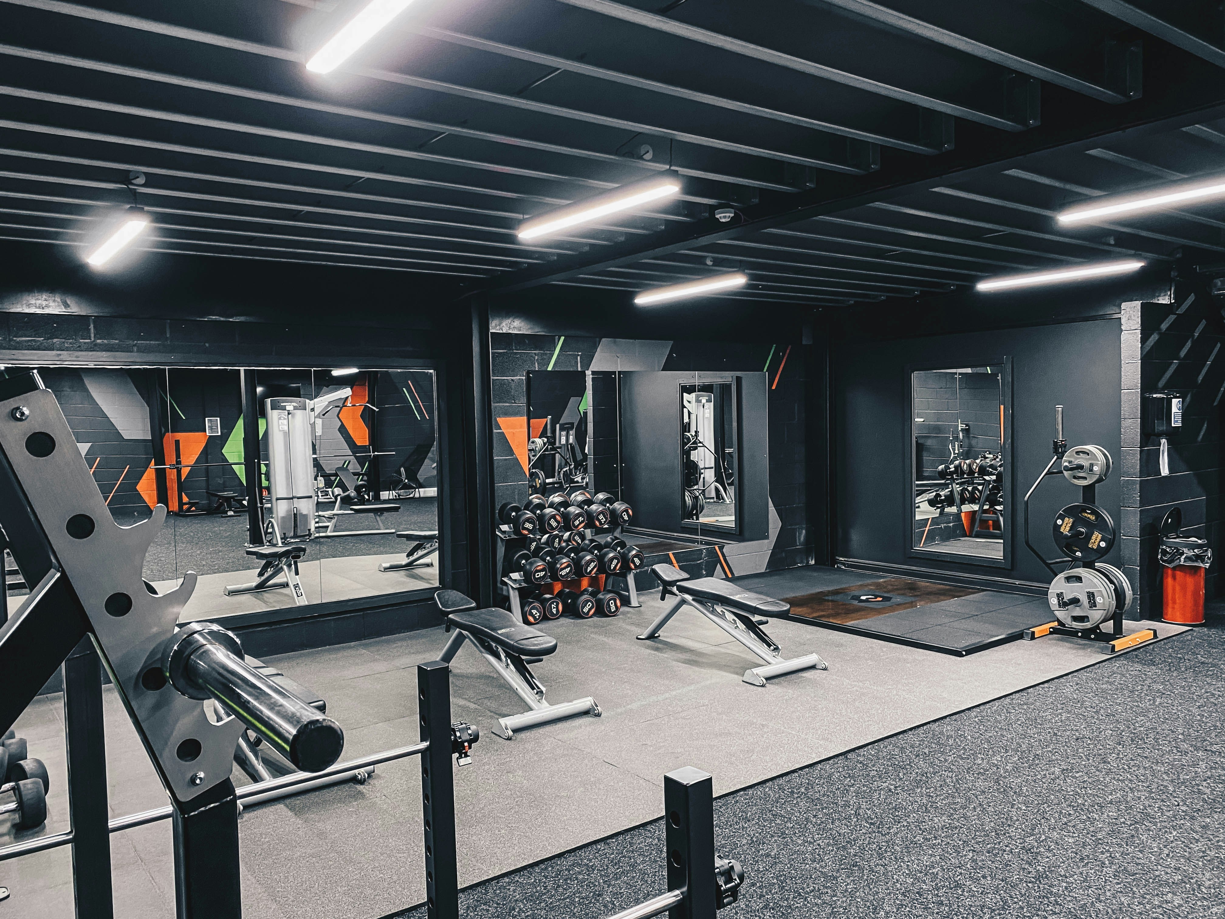 Modern fitness studio with bright lighting, yoga mats, and mirrored walls