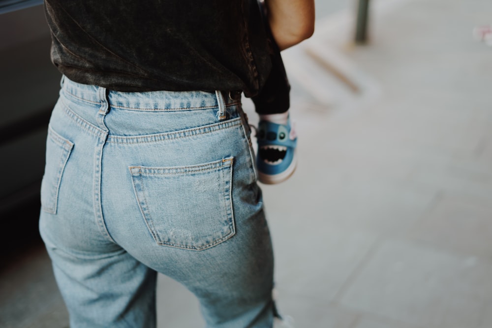 a person wearing blue jeans and a black shirt