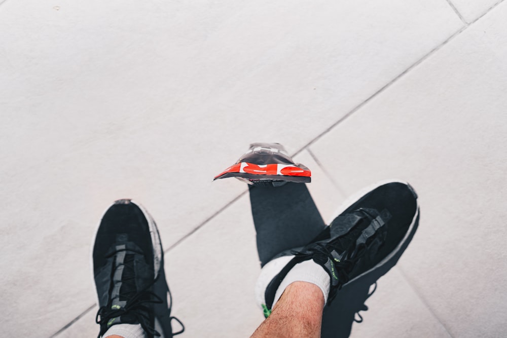 a person standing on a sidewalk with their feet on a skateboard