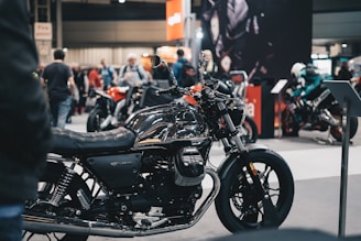 a black motorcycle parked in front of a crowd of people