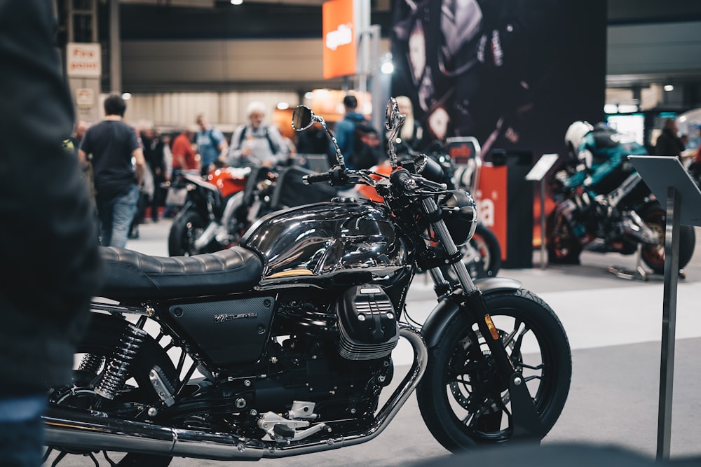a black motorcycle parked in front of a crowd of people