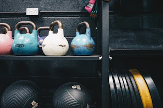 High-end kettlebells arranged neatly on a clean white surface with soft violet lighting.