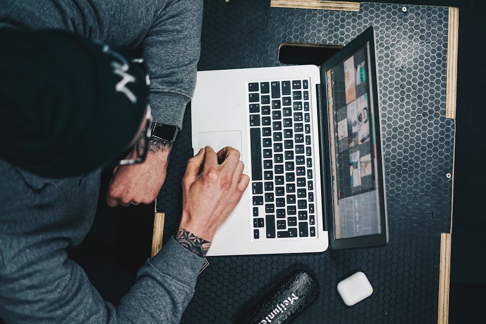 a man sitting at a desk using a laptop computer