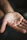 Close-up of a hand holding a transdermal patch with a blurred natural background.