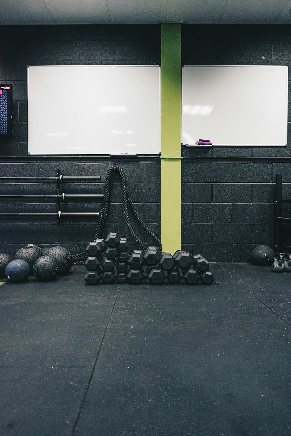 a gym with balls and a chain on the floor