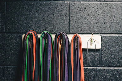 A set of colorful resistance bands hanging neatly on a wall rack.