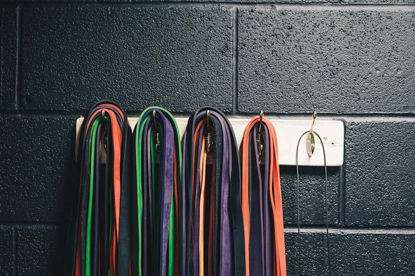 Person stretching with resistance bands in a bright home gym.