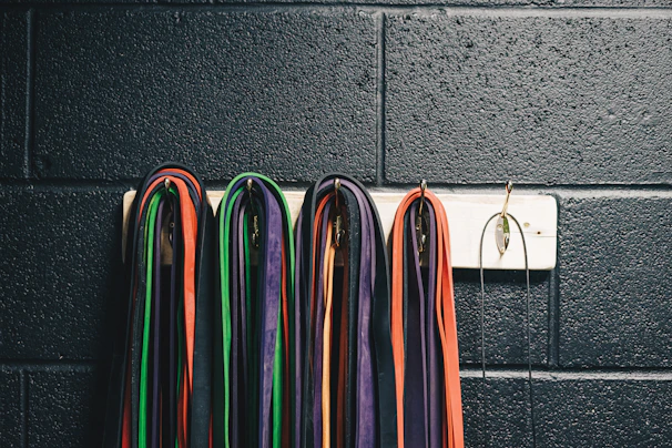 Close-up of colorful resistance bands neatly arranged on a wooden floor.