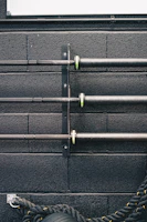 a black wall with metal pipes and a tire