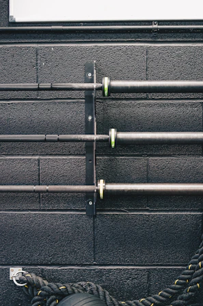 a black wall with metal pipes and a tire
