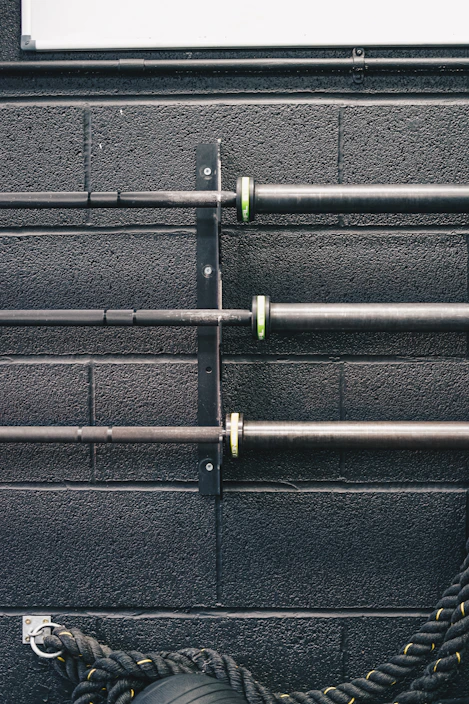 Close-up of a rugged powerlifting belt and chalk bag resting on a gym bench under bright lights.