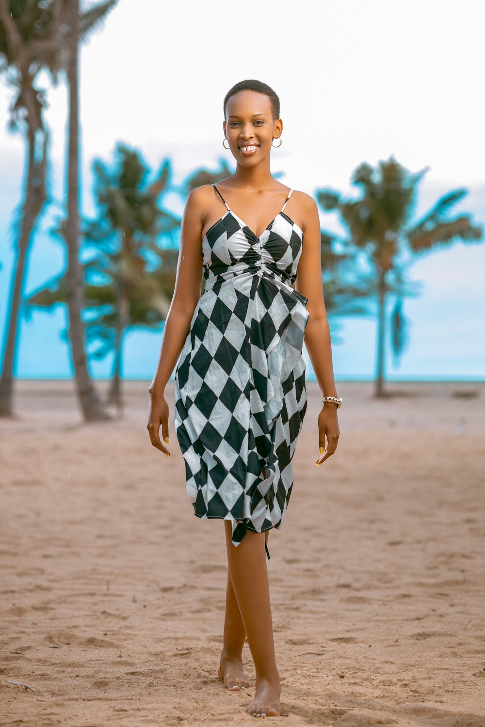 a woman in a checkered dress on the beach