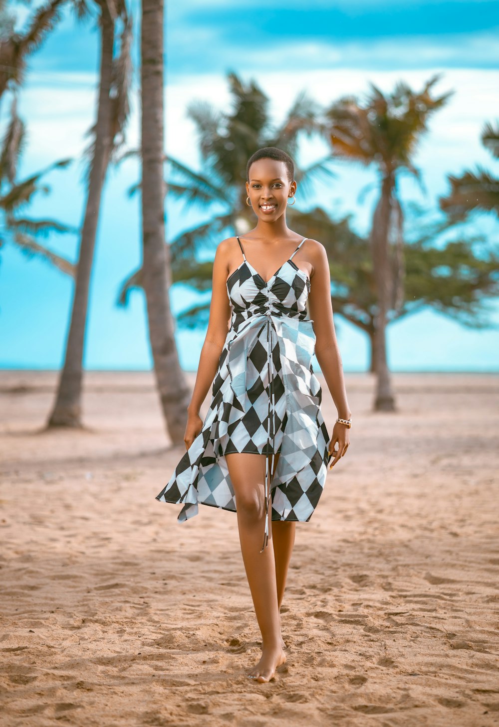 a woman in a dress walking on a beach