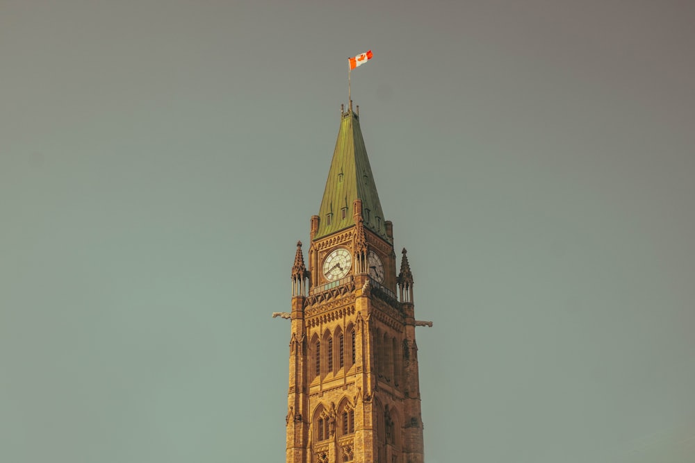 a tall clock tower with a flag on top