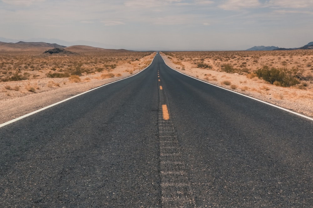 an empty road in the middle of the desert