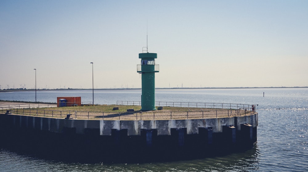 Ein Leuchtturm, der auf einem Pier neben dem Meer sitzt