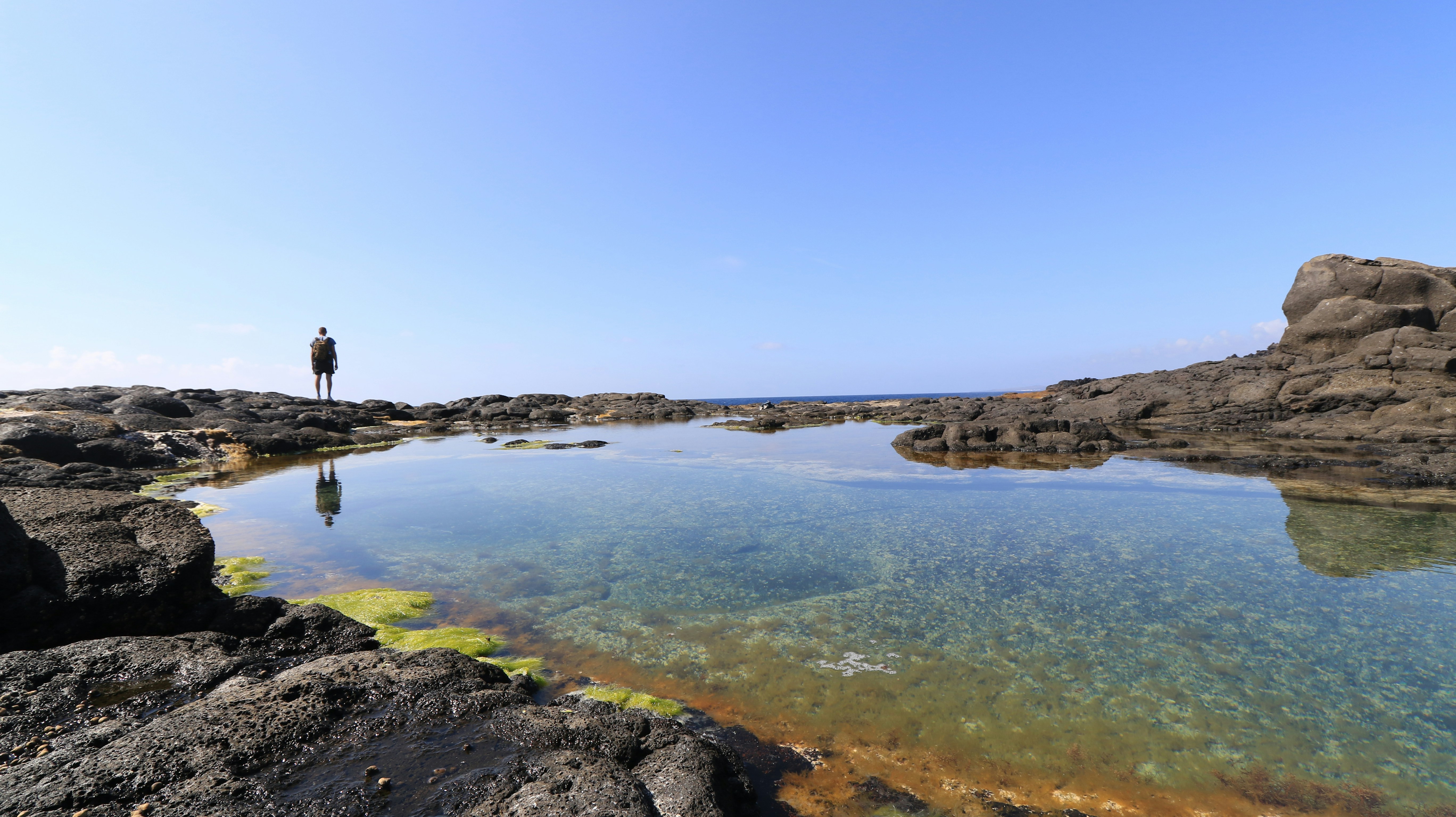Kalbarri to Ningaloo: Shark Bay and the Coral Coast – a man standing on a rocky shore next to a body of water