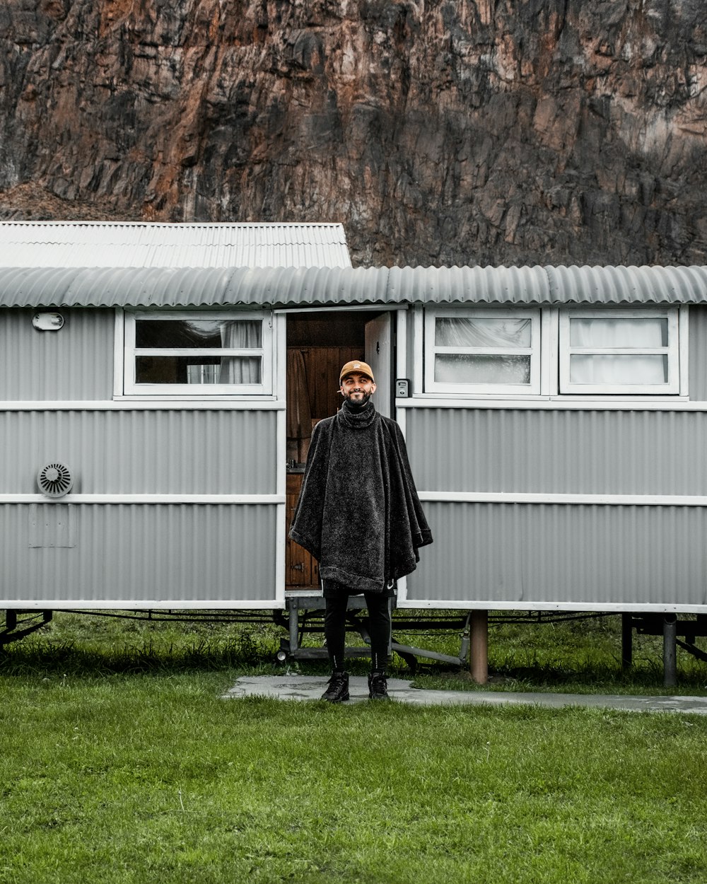 a man standing in front of a tiny house