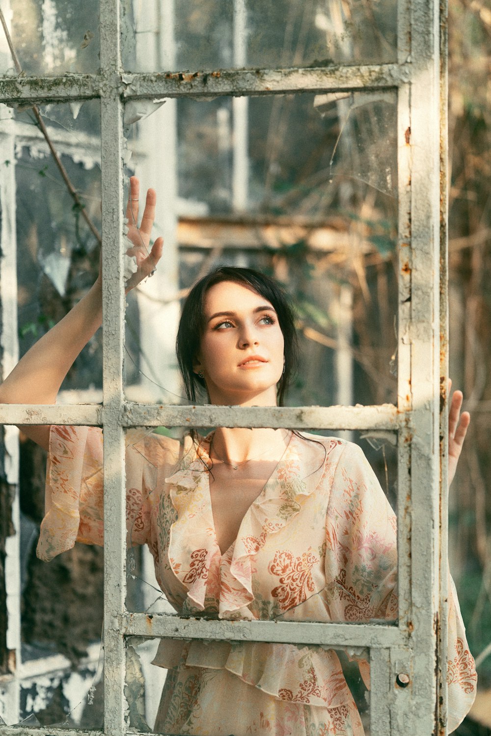 a woman in a dress looking out of a window