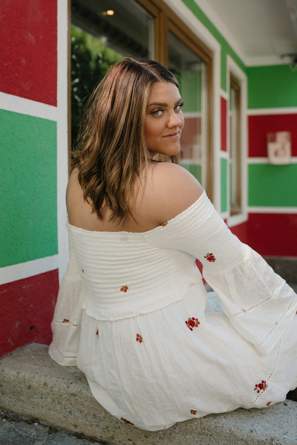 a woman in a white dress sitting on a step