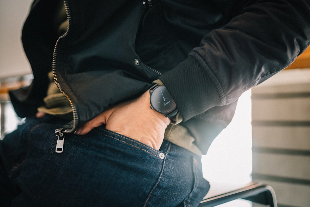 a person sitting on a chair with their hands in their pockets