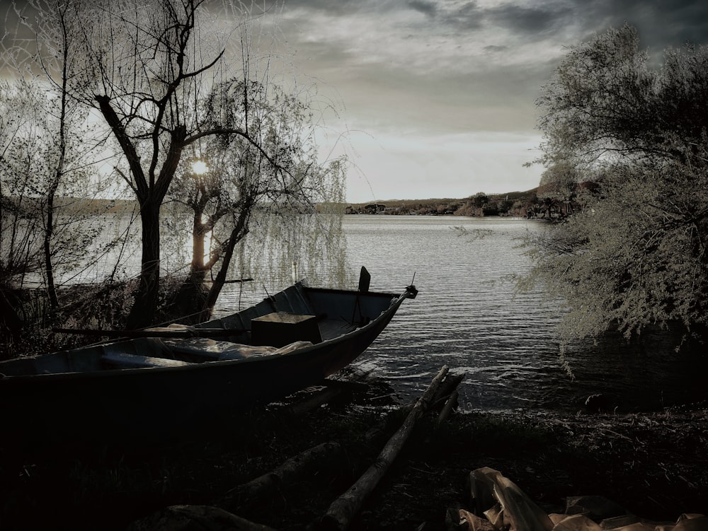 a boat sitting on the shore of a lake