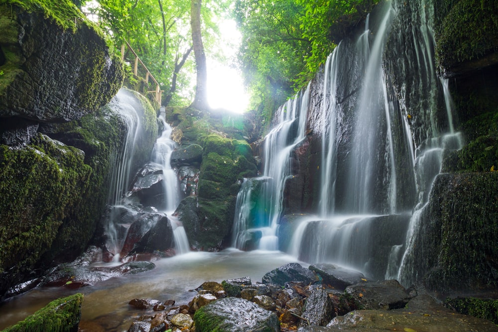 a small waterfall in the middle of a forest