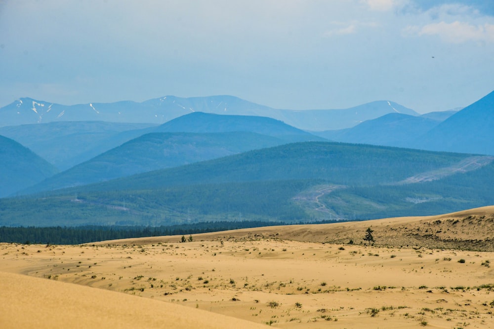 a view of a mountain range from a sand dune