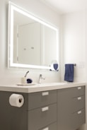 A sleek, illuminated bathroom mirror with soft glowing LED lights around the edges.