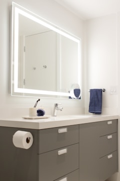 A sleek, illuminated bathroom mirror with soft glowing LED lights around the edges.