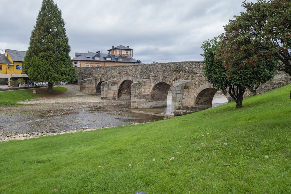 a stone bridge over a river in a park