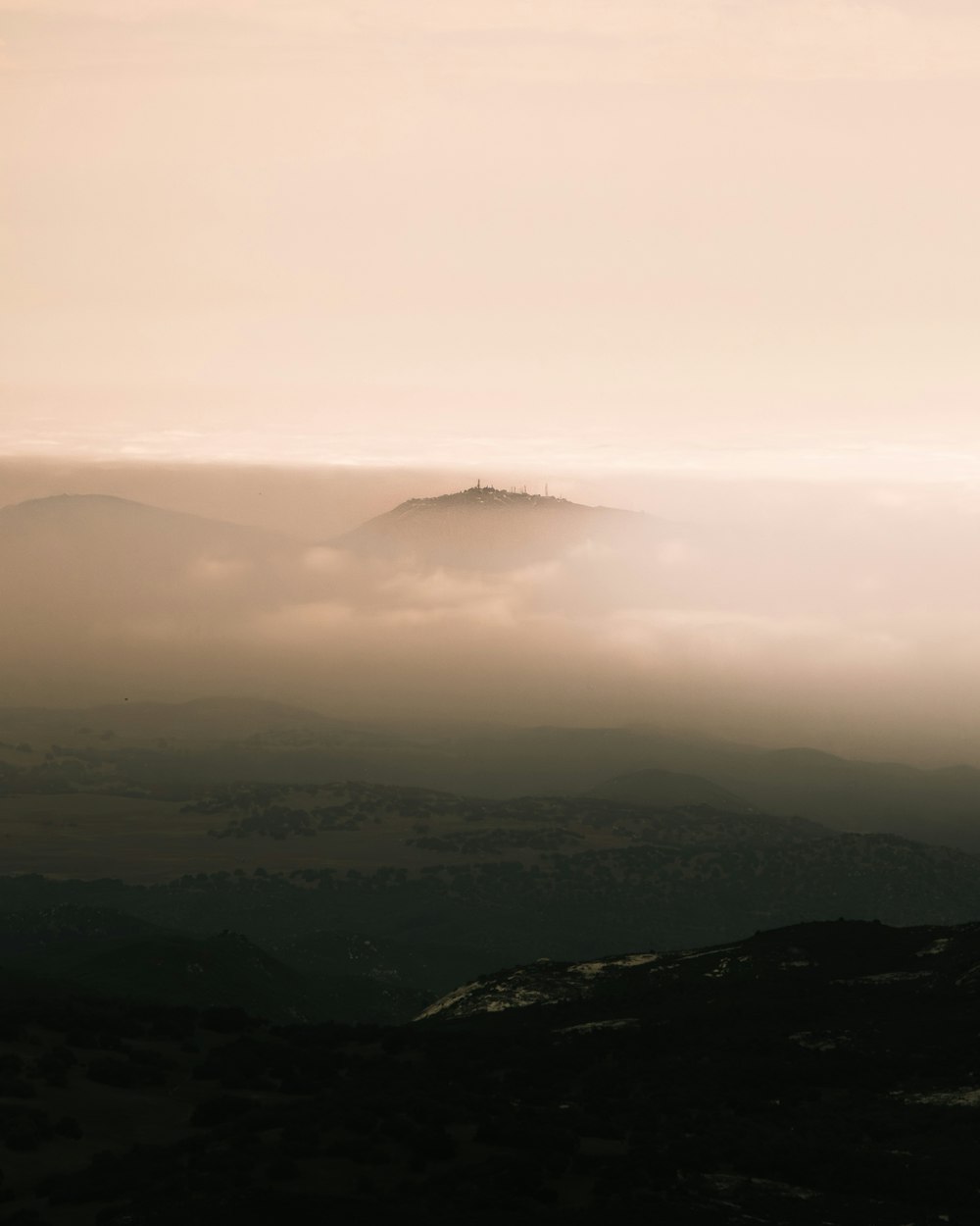 ein Hügel, der in Nebel und tiefliegende Wolken gehüllt ist
