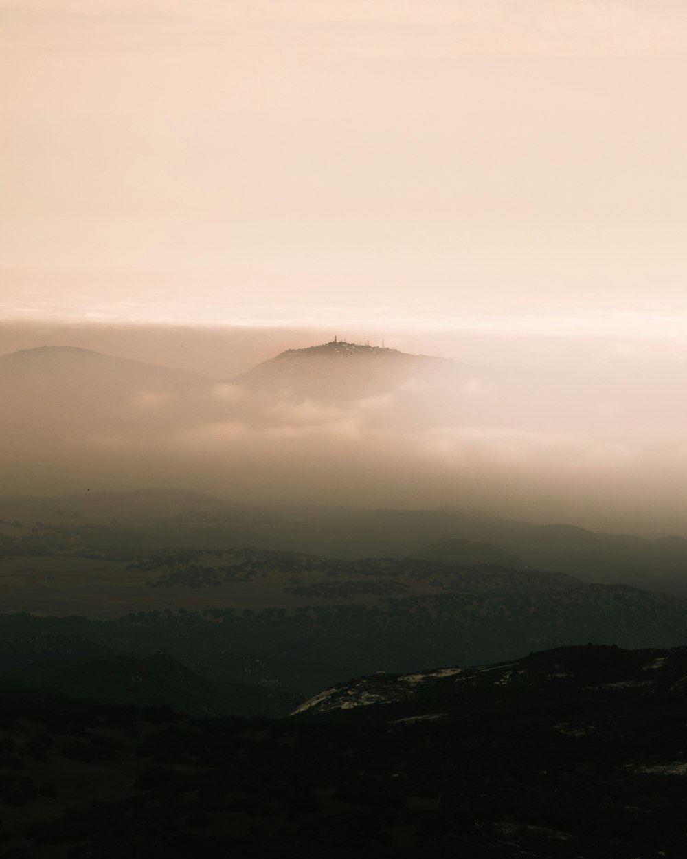 a hill covered in fog and low lying clouds