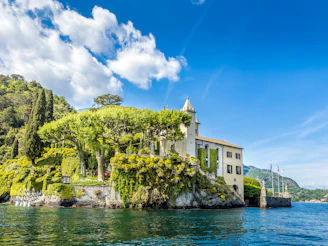 A serene villa surrounded by lush greenery under a clear blue sky.