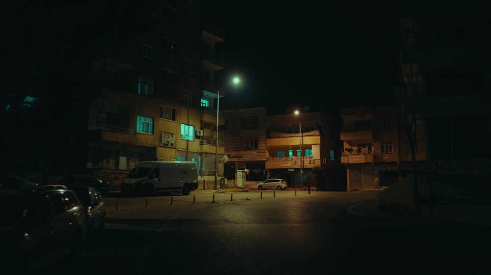 a street at night with cars parked on the side of the road