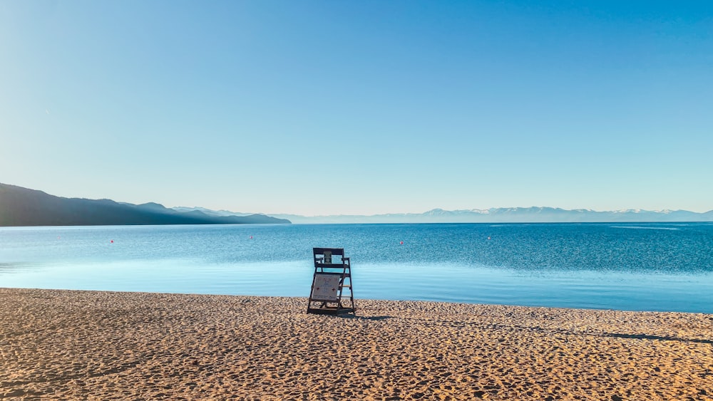 a chair sitting on the beach next to the ocean