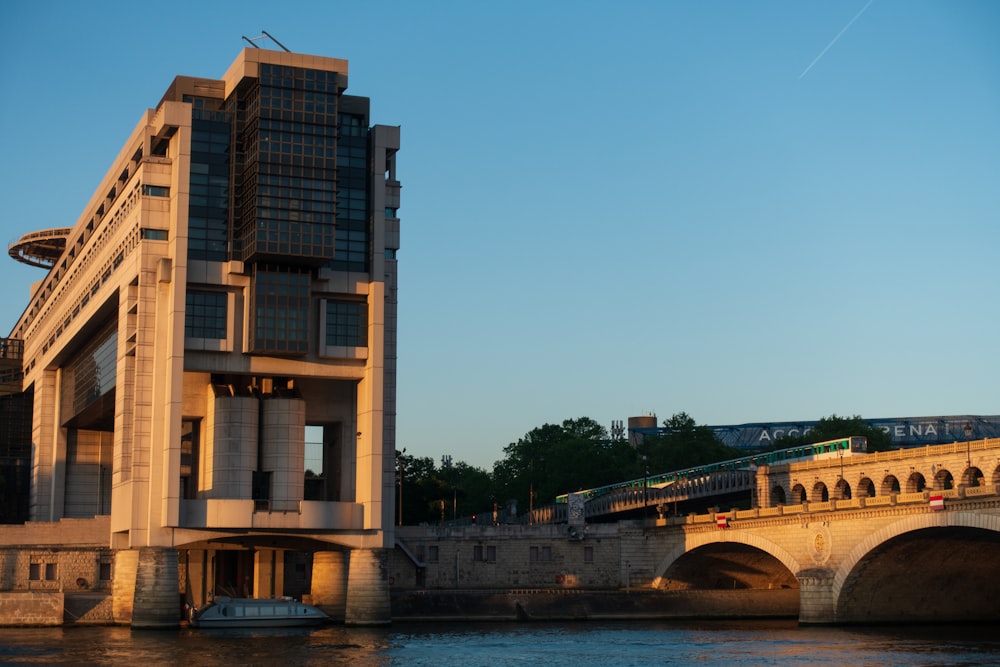 a bridge over a body of water next to a tall building