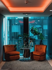 Spacious seating area with plush armchairs and side table.