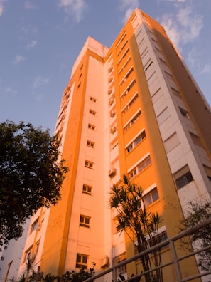 Elegant high-rise residential building in Noida at sunset with warm lighting.