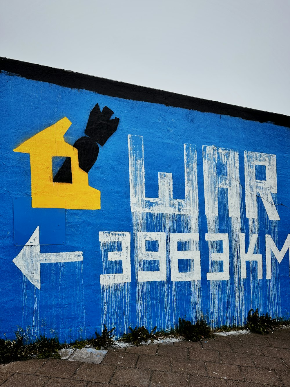 a blue wall with a yellow house painted on it