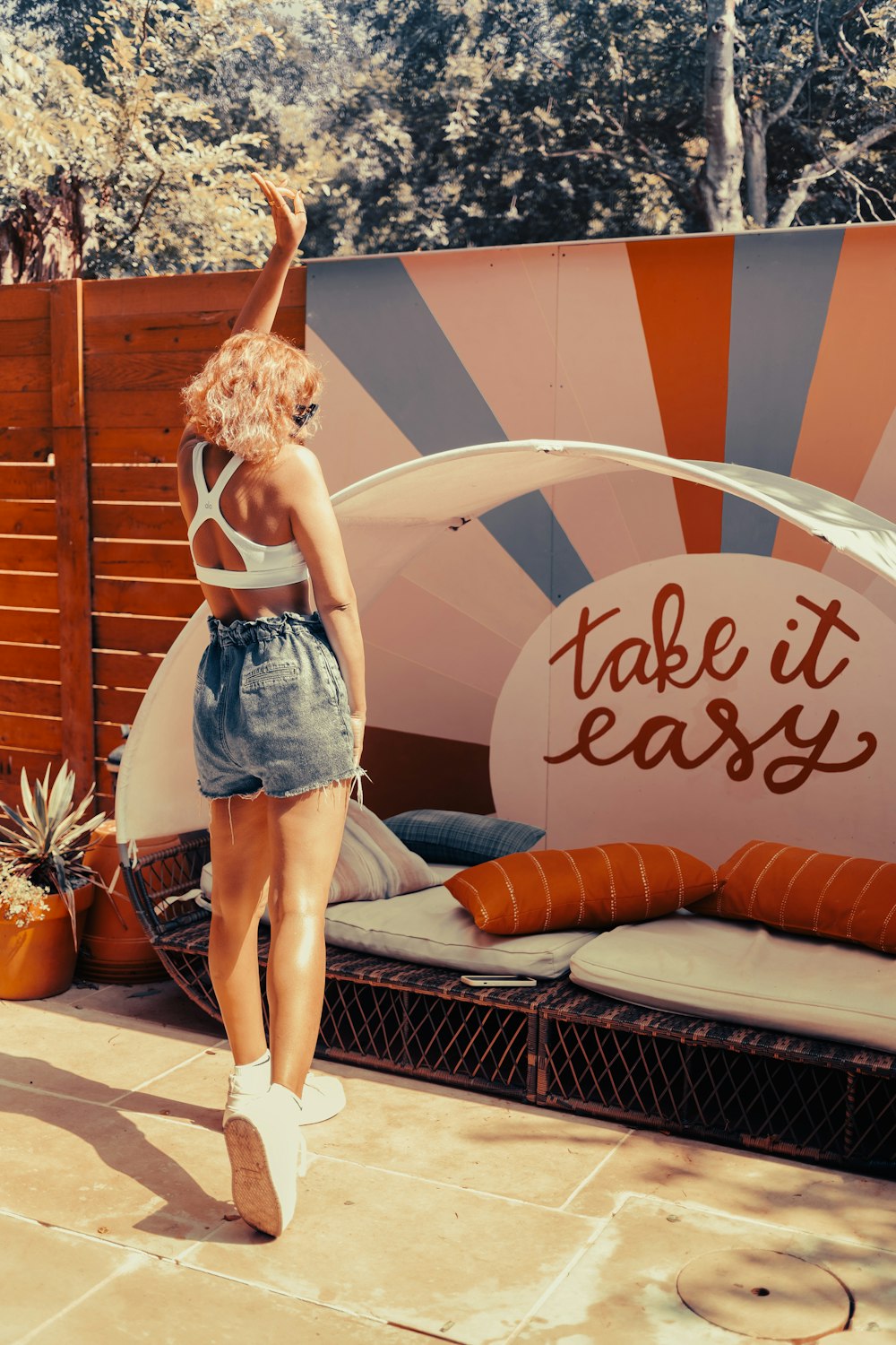 a woman standing in front of a fake surfboard