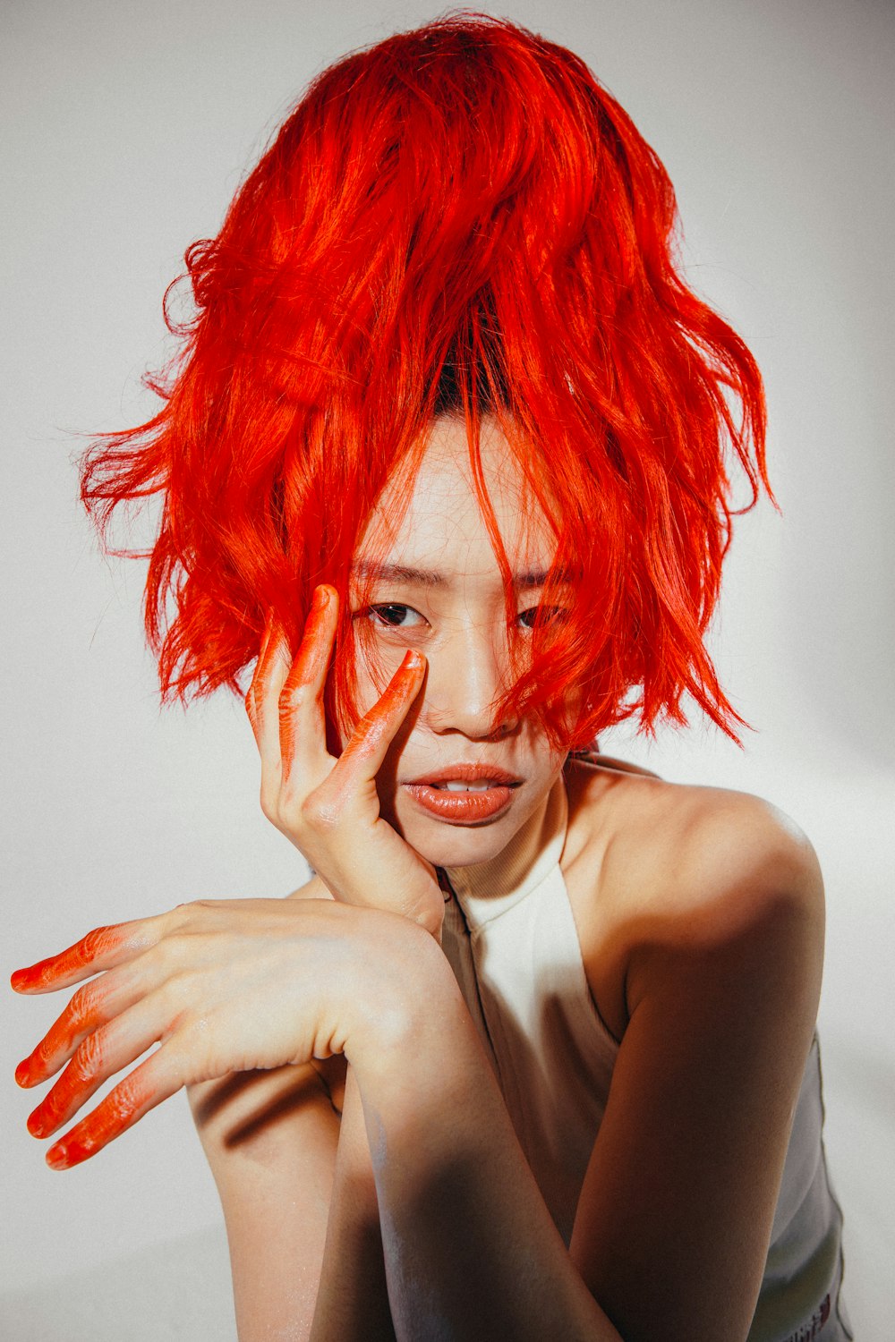 a woman with bright red hair is posing for a picture
