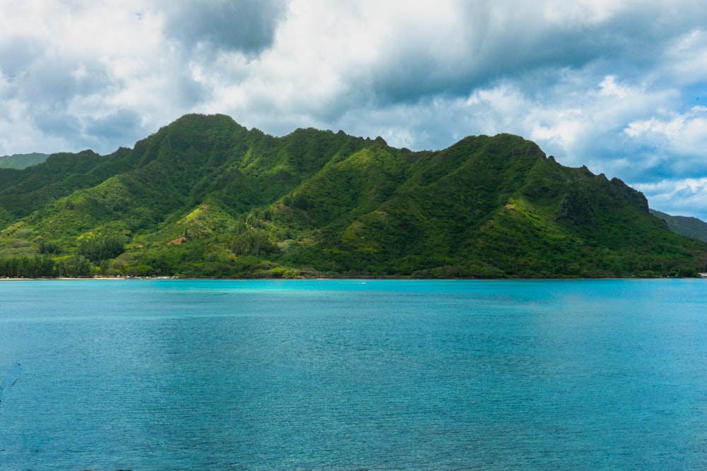 a large body of water with a mountain in the background